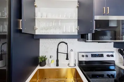 a kitchen with a sink and a stove at Stylish 3BR Steps to Canal, Easy Drive to Falls in Port Colborne