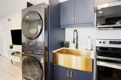 a kitchen with blue cabinets and a sink and a mirror at Stylish 3BR Steps to Canal, Easy Drive to Falls in Port Colborne