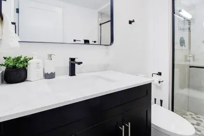 a bathroom with a white sink and a mirror at Stylish 3BR Steps to Canal, Easy Drive to Falls in Port Colborne