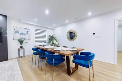 a dining room with a wooden table and blue chairs at Lux 7 Bedroom Home [Near Rogers Stadium/Downsview] in Toronto