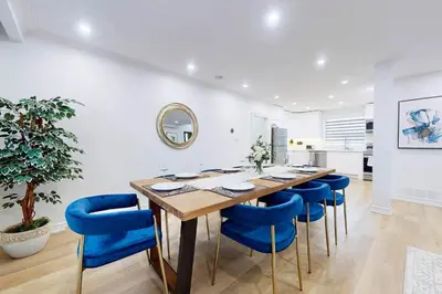a dining room with a table and blue chairs at Lux 7 Bedroom Home [Near Rogers Stadium/Downsview] in Toronto