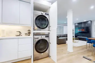 a kitchen with a washing machine in a room at Lux 7 Bedroom Home [Near Rogers Stadium/Downsview] in Toronto