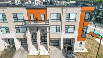 an apartment building with a car parked in front of it at Modern Vaughan Retreat, 10 mins to Pearson Airport, Vaughan Mall in Vaughan