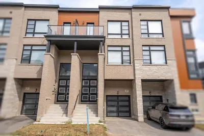 a building with a car parked in front of it at Modern Vaughan Retreat, 10 mins to Pearson Airport, Vaughan Mall in Vaughan