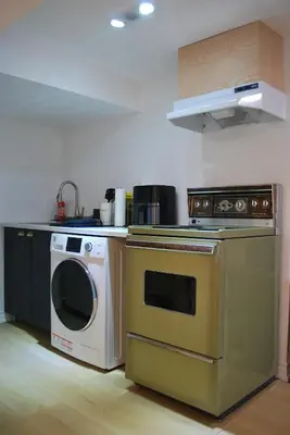 a kitchen with a stove and a washing machine at Cozy Private Room with Shared Bathroom in Toronto in Toronto
