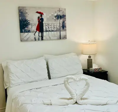 a white bed with a heart shaped towel on it at Cozy Private Room with Shared Bathroom in Toronto in Toronto
