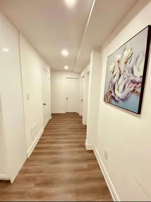 a hallway with white walls and a painting on the wall at Cedar Hedge Private Basement Apartment in Milton