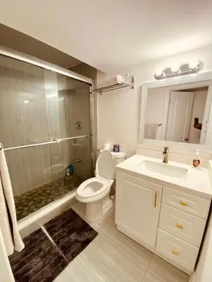 a bathroom with a toilet and a sink and a shower at Cedar Hedge Private Basement Apartment in Milton