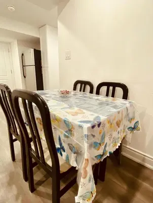 a dining room table with a flowered table cloth at Cedar Hedge Private Basement Apartment in Milton