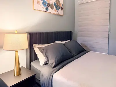 a bedroom with a bed with a lamp on a table at Designer 2BR Suite - Steps to Vic Hospital - Wortley in London