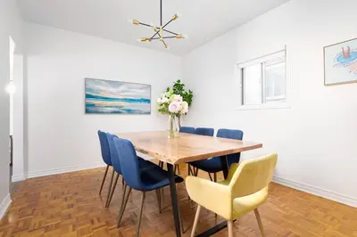 a dining room with a wooden table and blue chairs at Charming 4 Bed Home + 2Parking in Toronto