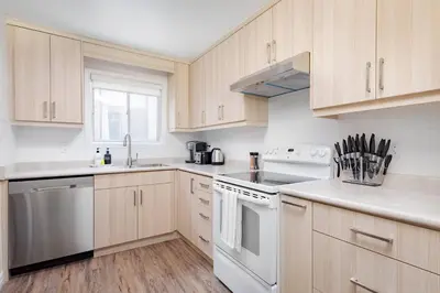 a kitchen with white appliances and wooden cabinets at Charming 4 Bed Home + 2Parking in Toronto