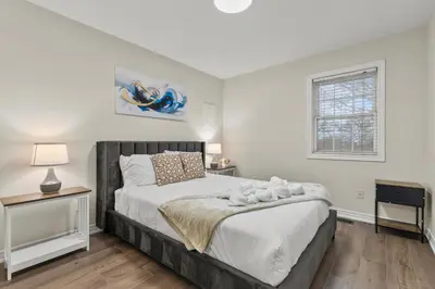 a bedroom with a large bed and a window at Chelsea Suite 3BR, 1B with parking for 28plus stays in St. Catharines
