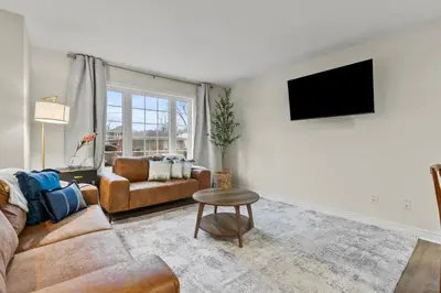 a living room with a couch and a table at Chelsea Suite 3BR, 1B with parking for 28plus stays in St. Catharines
