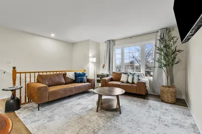 a living room with two couches and a table at Chelsea Suite 3BR, 1B with parking for 28plus stays in St. Catharines