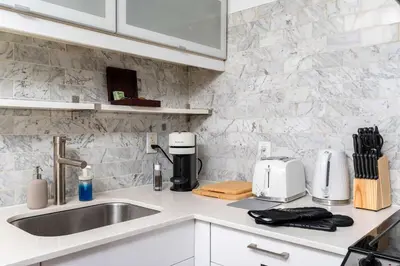 a kitchen counter with a sink and a coffee maker at Contemporary 1BR Basement Suite with Private Entrance in Toronto