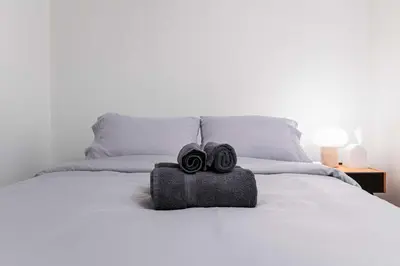 two towels are sitting on top of a bed at Contemporary 1BR Basement Suite with Private Entrance in Toronto