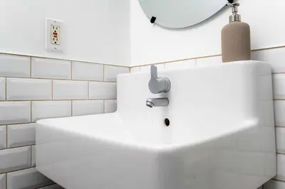 a white sink in a bathroom with a mirror at Contemporary 1BR Basement Suite with Private Entrance in Toronto