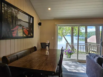 a dining room with a wooden table and a large window at Olga's Bay Lakehouse in Minett