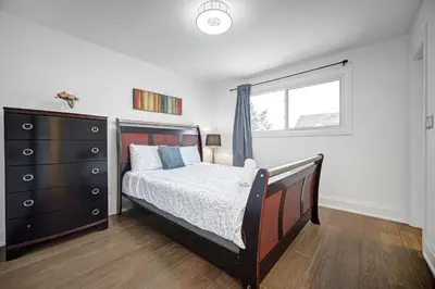 a bedroom with a bed and a dresser and a window at 166 Main - Family Getaway 5BR Home with Backyard & Parking in Markham