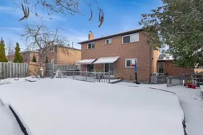 a house with a fence and a snow covered yard at 166 Main - Family Getaway 5BR Home with Backyard & Parking in Markham