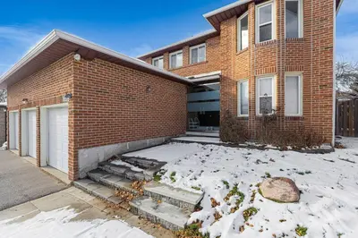 a brick house with snow in front of it at 166 Main - Family Getaway 5BR Home with Backyard & Parking in Markham