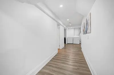 an empty hallway with white walls and wood floors at 166 Basement - Cozy 3BR Markham Stay, Patio, Parking, Pet-Free in Markham