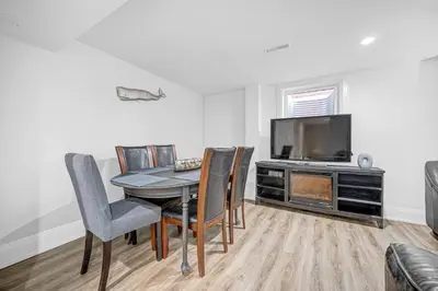 a dining room with a table and chairs and a television at 166 Basement - Cozy 3BR Markham Stay, Patio, Parking, Pet-Free in Markham