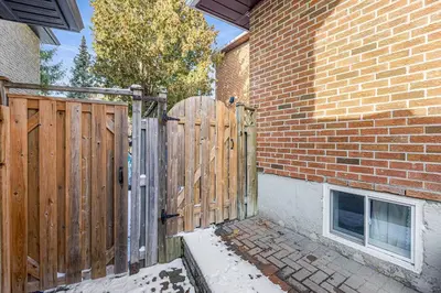 a wooden gate in front of a brick building at 166 Basement - Cozy 3BR Markham Stay, Patio, Parking, Pet-Free in Markham