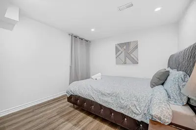 a white bedroom with a bed and a window at 166 Basement - Cozy 3BR Markham Stay, Patio, Parking, Pet-Free in Markham