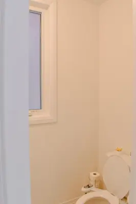 a bathroom with a toilet and a window at Spacious 4BR Home with EV Charger in Cambridge