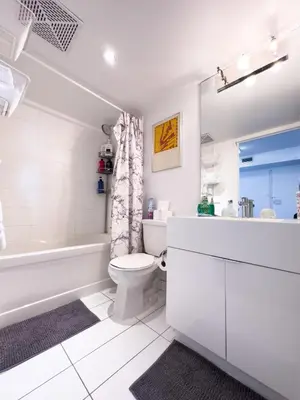 a white bathroom with a tub and a toilet and a sink at CityPlace Lofts Free Parking in Toronto