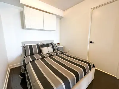 a bedroom with a bed with black and white stripes at CityPlace Lofts Free Parking in Toronto