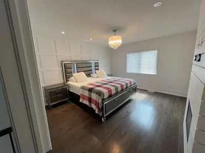 a bedroom with a bed with a striped blanket at Warm Stylish 4 Bedroom Home 3 Bath in Ajax