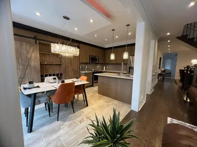 a kitchen and living room with a table and chairs at Warm Stylish 4 Bedroom Home 3 Bath in Ajax