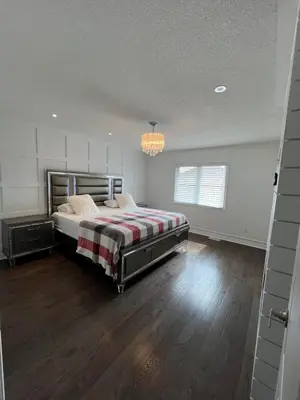 a bedroom with a bed and a chandelier at Warm Stylish 4 Bedroom Home 3 Bath in Ajax