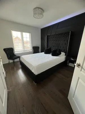 a bedroom with a bed with two black bags on it at Warm Stylish 4 Bedroom Home 3 Bath in Ajax