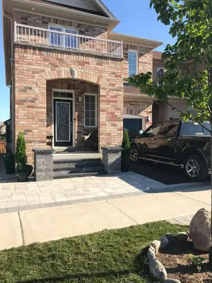 a car parked in front of a brick house at Warm Stylish 4 Bedroom Home 3 Bath in Ajax