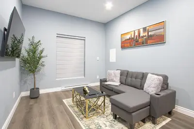 a living room with a couch and a chair at Quiet, Soundproof 1-BR Suite Near Victoria Hospital with Parking & Balcony in London