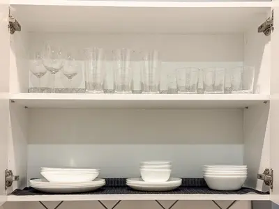 a shelf filled with glasses and plates and bowls at Quiet, Soundproof 1-BR Suite Near Victoria Hospital with Parking & Balcony in London