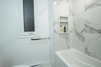 a white bathroom with a shower and a sink at Quiet, Soundproof 1-BR Suite Near Victoria Hospital with Parking & Balcony in London