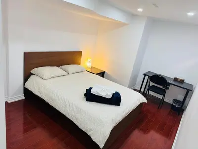 a bedroom with a bed with a black bag on it at Private Deluxe basement suiteP1 in Mississauga