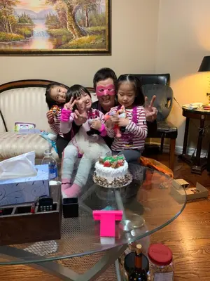 a man and three children sitting on a table with a cake at Private Deluxe basement suiteP1 in Mississauga