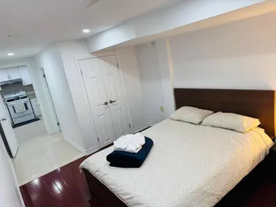 a bedroom with a bed with a blue bag on it at Private Deluxe basement suiteP1 in Mississauga