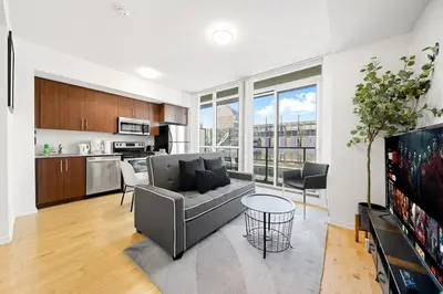 a living room with a couch and a kitchen at Downtown Toronto CN Tower Condo in Toronto
