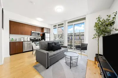 a living room with a couch and a kitchen at Downtown Toronto CN Tower Condo in Toronto