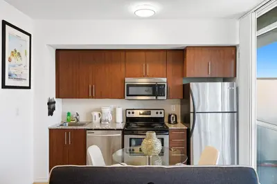 a kitchen with a glass table and a microwave at Downtown Toronto CN Tower Condo in Toronto