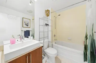 a bathroom with a sink and a toilet and a tub at Downtown Toronto CN Tower Condo in Toronto