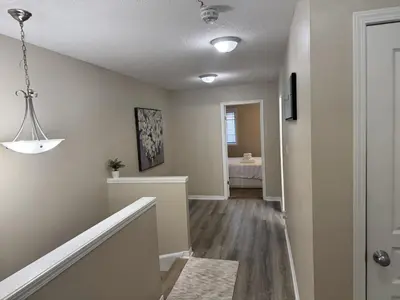 a hallway of a home with white walls and wood floors at Gorgeous 3-Bedroom 3Bathroom house in Kitchener