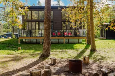 a house with a deck and trees in the yard at Lakefront Englewood Villas Private BBQ and Lakeview in Lakefield